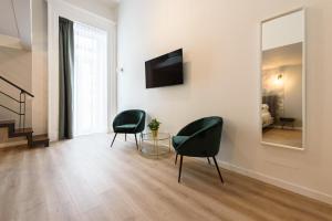 un soggiorno con 2 sedie e uno specchio di Guest House 121 Luxury Apartments a Napoli