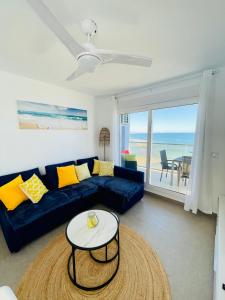 a living room with a blue couch and a table at Seafront La Manga Apartment in La Manga del Mar Menor