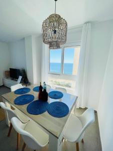 a dining room with a table with blue plates on it at Seafront La Manga Apartment in La Manga del Mar Menor