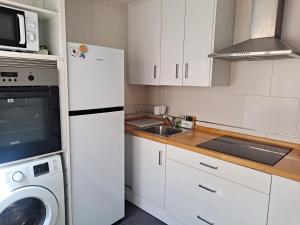 a kitchen with a white refrigerator and a dishwasher at Ático con terraza in Cieza