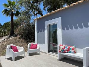 two chairs with pillows sitting outside of a house at Monte Teu in São Luis