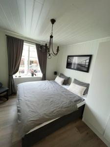 a bedroom with a white bed and a chandelier at Light home apartment Alesund with free parking in Ålesund