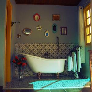 a bathroom with a white bath tub in a room at Villa Amore Floripa in Florianópolis