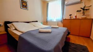 ein Schlafzimmer mit einem Bett mit zwei Handtüchern darauf in der Unterkunft MIMO APARTMAN in Hajdúszoboszló