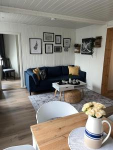 a living room with a blue couch and a table at Light home apartment Alesund with free parking in Ålesund