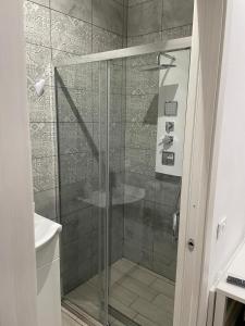 y baño con ducha y puerta de cristal. en B&B A FACCI VISTA, en Porto Empedocle