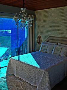 a bedroom with a large bed and a chandelier at Villa Amore Floripa in Florianópolis