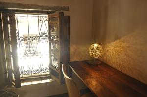 una lámpara sentada en una mesa junto a una ventana en Dar 7 Louyat, en Fez