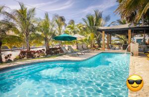 una piscina con sombrilla y una bola amarilla en Ocean Front Villa, 2 Private Pools, BBQ, Tennis court and more!, en Vega Baja