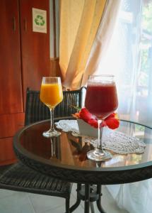 dois copos de bebidas numa mesa de vidro em Cabañas MANA NUI INN em Hanga Roa