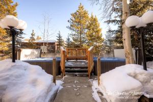 eine Veranda mit einer Holzbank im Schnee in der Unterkunft Charming & Renovated Two-Bedroom Condo Nestled Near a Serene Mountain Stream PM1D in Breckenridge