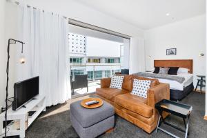 ein Wohnzimmer mit einem Bett, einem Sofa und einem TV in der Unterkunft Princes Wharf Boutique Apartments in Auckland