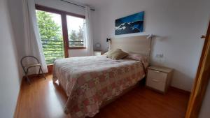 1 dormitorio con cama y ventana grande en CHECK IN CASAS Pirita, en Cerler