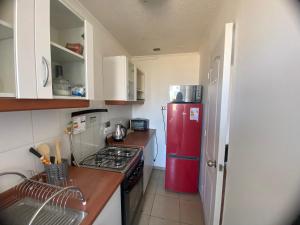 eine kleine Küche mit einem roten Kühlschrank in der Unterkunft Apartamento boldo Curicó in Curicó
