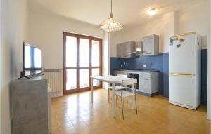 a kitchen with a table and a white refrigerator at 2 Bedroom Nice Apartment In Santo Stefano Al Mare in Santo Stefano al Mare