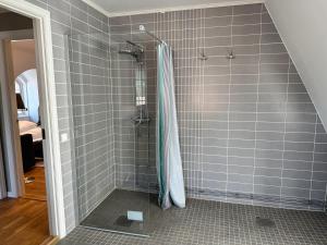 a shower in a bathroom with gray tiles at Oxgården in Vimmerby +82 photos