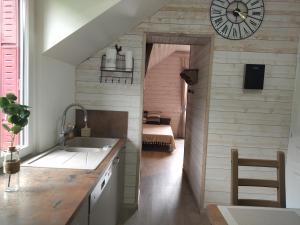 a kitchen with a clock on the wall and a bedroom at Appartement chaleureux et cosy in Le Mont-Dore