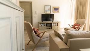 a living room with a couch and chairs and a television at Triena Quality Villas in Gaios