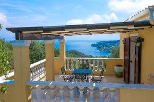 ガイオスにあるTriena Quality Villasのテーブルと椅子付きの家のバルコニーから景色を望めます。
