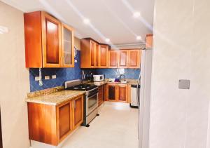 a kitchen with wooden cabinets and a stove top oven at Exclusive 3 BDR, Gym & Pool, SeaView, Luxury Tower in Santo Domingo