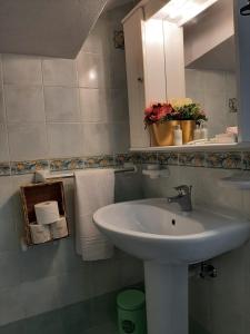 a bathroom with a sink and a mirror and towels at Casa Borgo Sant'Angelo in Ischia