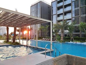 une piscine en face d'un grand bâtiment dans l'établissement Luxury Condos at Empire City, à Hô-Chi-Minh-Ville