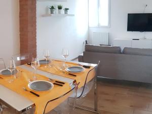 una mesa de comedor con copas de vino en la sala de estar en La Maison de André, en Scaltenigo
