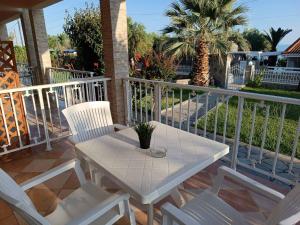 a white table and chairs on a balcony at Sofia studios in Nea Skioni