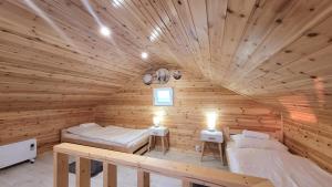 a log cabin with two beds in a room at Wierzbowa Ostoja - Domek letniskowy BOSMAN in Karsibór