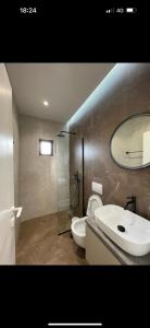 W łazience znajduje się umywalka, toaleta i lustro. w obiekcie Villa Xhefri 2 w Sarandzie