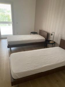 a room with two beds and two tables at TOT apartment in Policoro