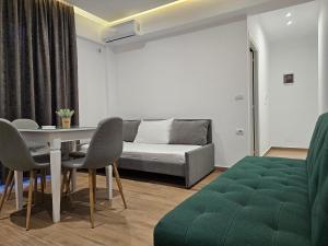 ein Wohnzimmer mit einem Sofa, einem Tisch und Stühlen in der Unterkunft Vila 31 in Sarandë