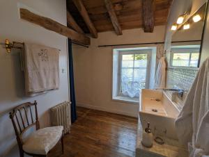 La salle de bains est pourvue d'un lavabo, d'une chaise et d'une fenêtre. dans l'établissement Château de Lavaud, à Montbron