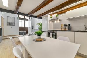 a white kitchen with a white table and chairs at Nice Central Loft in Vilanova i la Geltrú