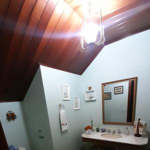 y baño con lavabo y espejo. en Casa Carvalho, en Campos do Jordão