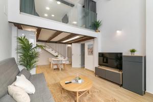 een woonkamer met een bank, een tv en een tafel bij Nice Central Loft in Vilanova i la Geltrú