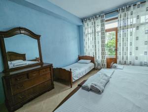 a bedroom with two beds and a mirror and a dresser at Vila Vadeha in Pogradec