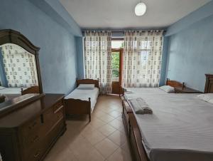 a bedroom with two beds and a sink and a mirror at Vila Vadeha in Pogradec