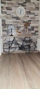 Todea House في ريغين: جلوس الدراجة في غرفة مع ساعة على الحائط
