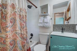 a bathroom with a toilet and a sink and a shower curtain at Completely Renovated Unit, Trendy Top Floor with Many Onsite Amenities PM7D in Breckenridge
