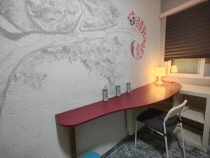 un escritorio en una habitación con una pared con un cuadro en Habitación Familiar en Madrid