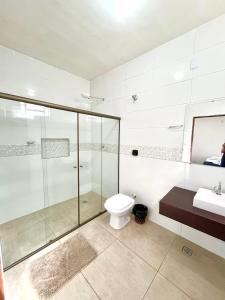 a bathroom with a shower and a toilet and a sink at Pousada Serra de São Thomé in São Thomé das Letras