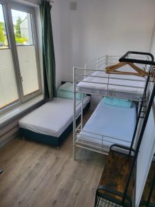 a room with two bunk beds and a window at Rooms4Rest Wiertnicza - Private rooms for tourists - ATR Consulting Sp, z o,o, in Warsaw