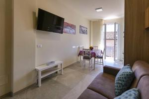 a living room with a couch and a tv on the wall at Casa Azzurra Vacanze in Porto San Giorgio