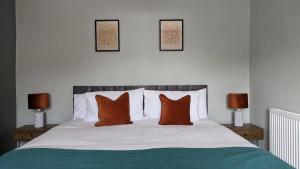 a bedroom with a bed with orange pillows and two lamps at Huge Weekly & Monthly Savings - Free Parking - Wi-Fi & Netflix in Wolverhampton