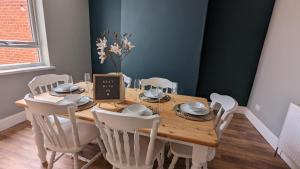 a dining room with a wooden table and white chairs at Huge Weekly & Monthly Savings - Free Parking - Wi-Fi & Netflix in Wolverhampton