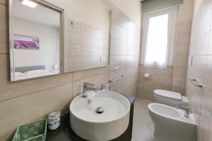 a bathroom with a sink and a toilet and a mirror at Casa Azzurra Vacanze in Porto San Giorgio +5 photos