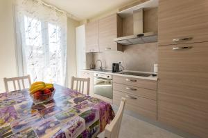 a kitchen with a table with a bowl of fruit on it at Casa Azzurra Vacanze in Porto San Giorgio