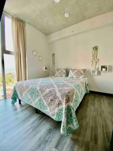 a bedroom with a bed and a large window at Cozy & Modern - Near the Airport in San José