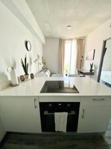 uma cozinha branca com um lavatório e um balcão em Cozy & Modern - Near the Airport em San José